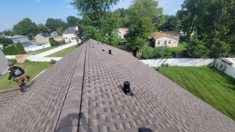 Roofer working on new architectural shingle roof in Rumson